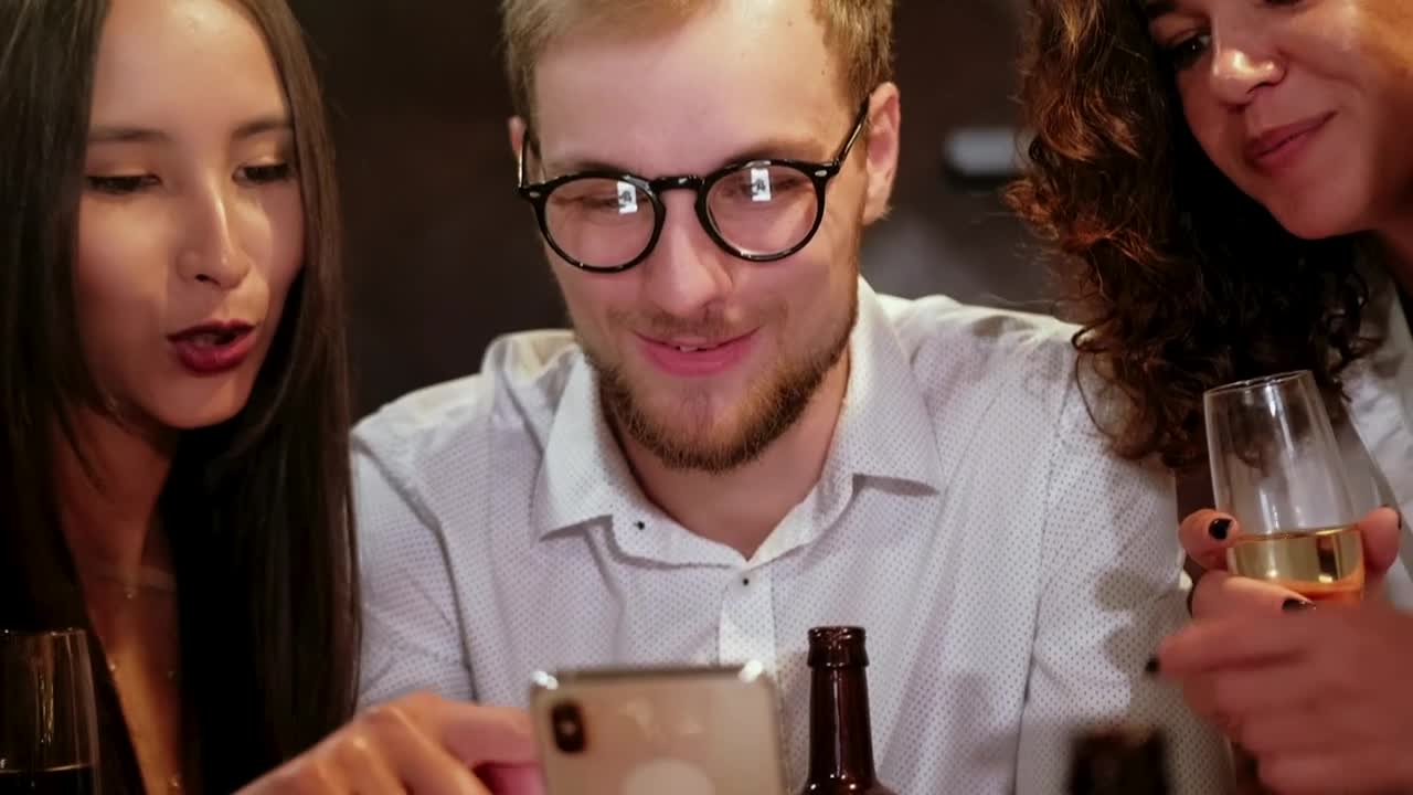Stock Video Happy Friends Looking At Photo In A Bar Animated Wallpaper