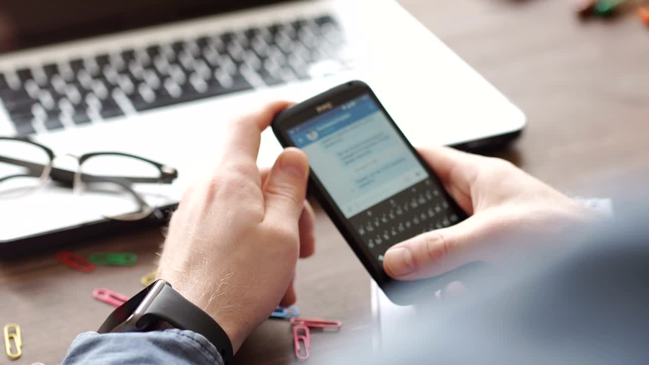 Stock Video Hands Scroll Through Facebook On Mobile At Desk Animated Wallpaper