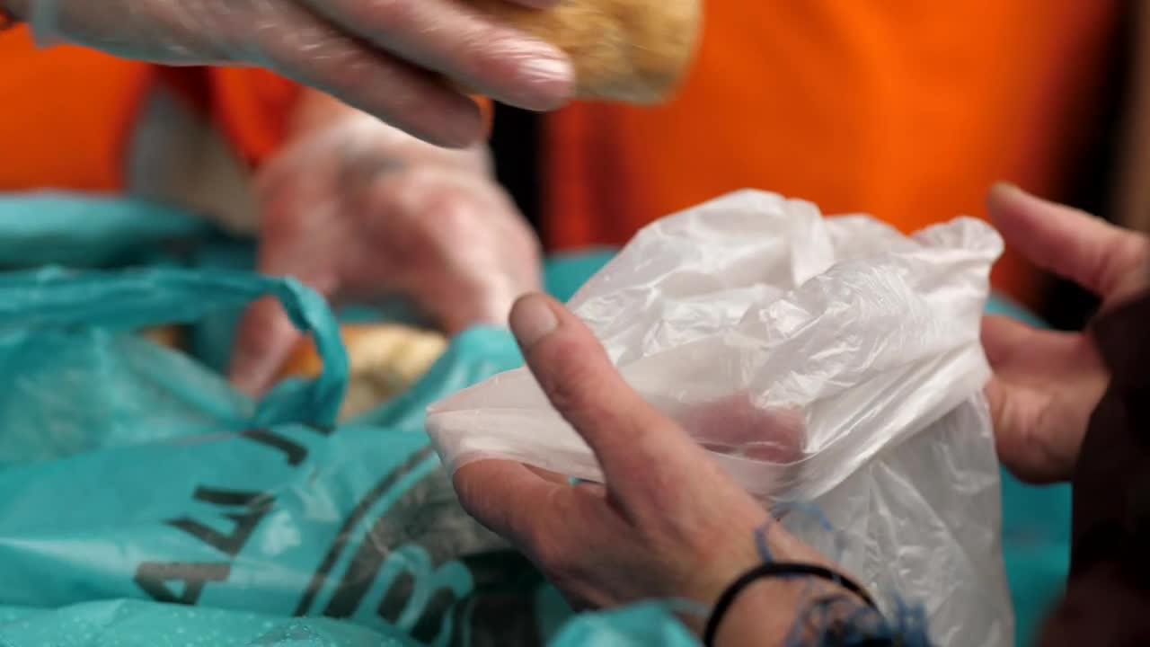 Stock Video Hands Of A Volunteer Gives Bread To Hungry People Animated Wallpaper