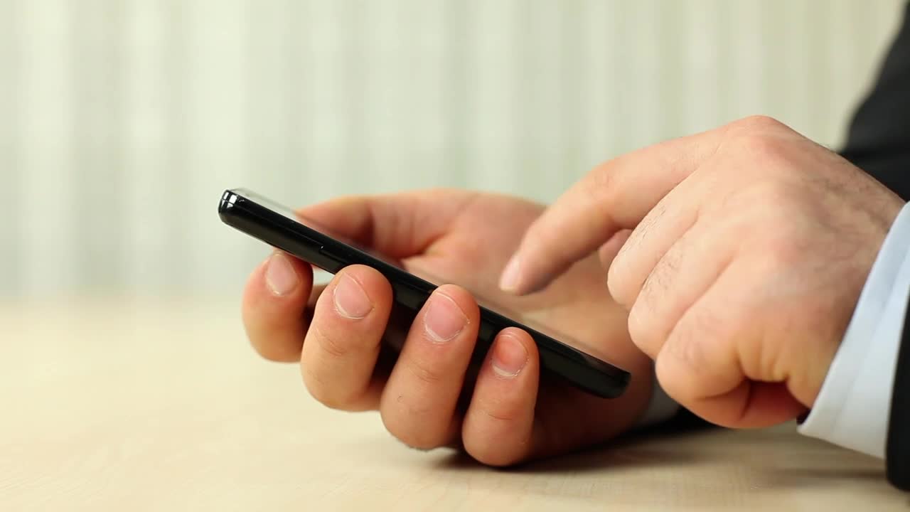 Stock Video Hands Of A Man In A Suit Using His Smartphone Animated Wallpaper