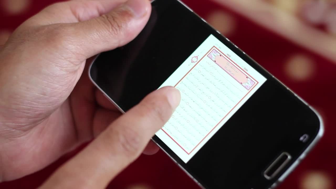 Stock Video Hands Hold A Cell To Reading The Quran In Digital Animated Wallpaper