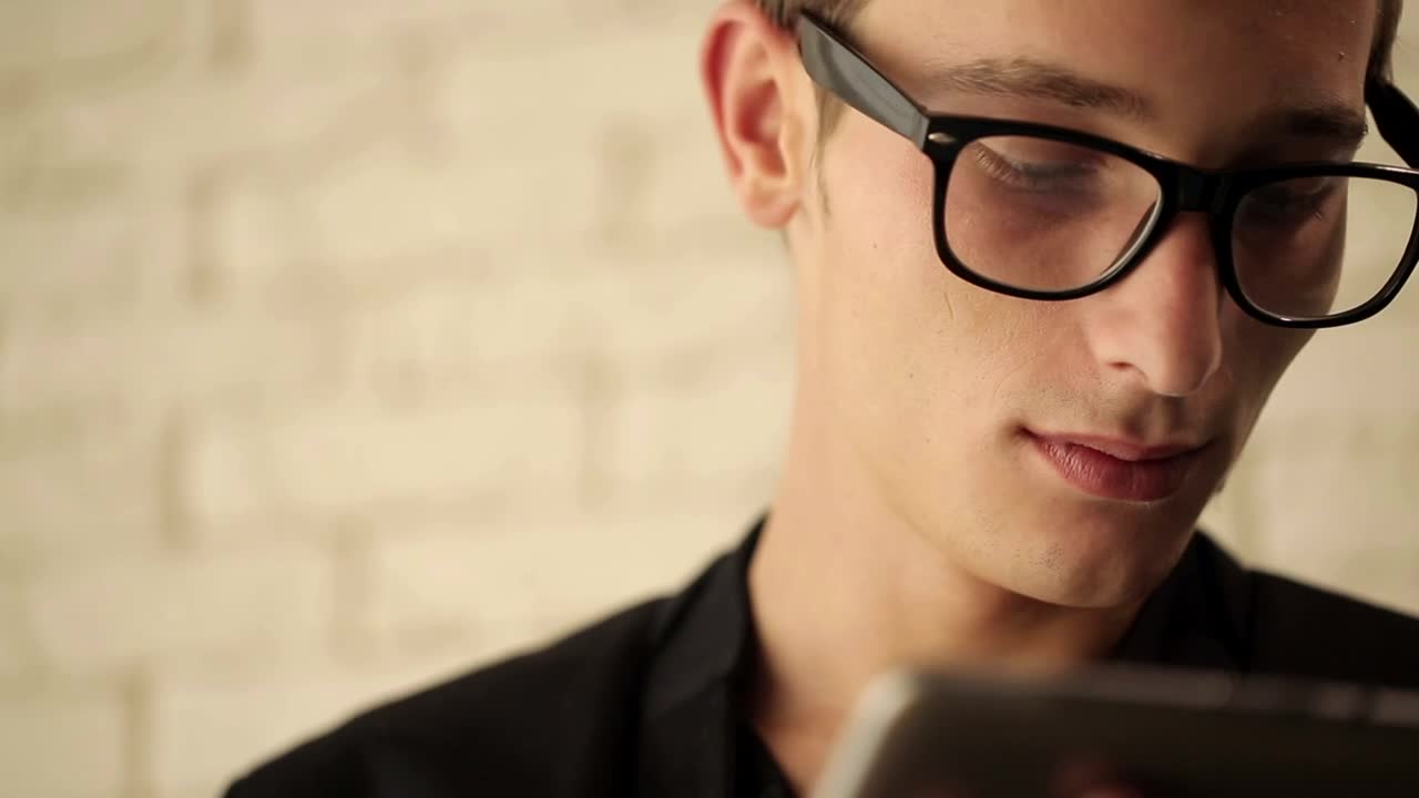 Stock Video Man In Glasses Working On His Tablet Animated Wallpaper