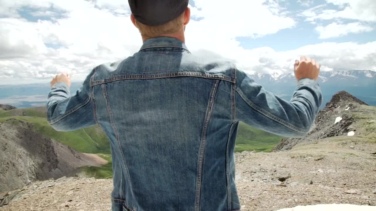 Stock Video Man In Denim Jacket Raises Arms To Mountain Landscape Animated Wallpaper