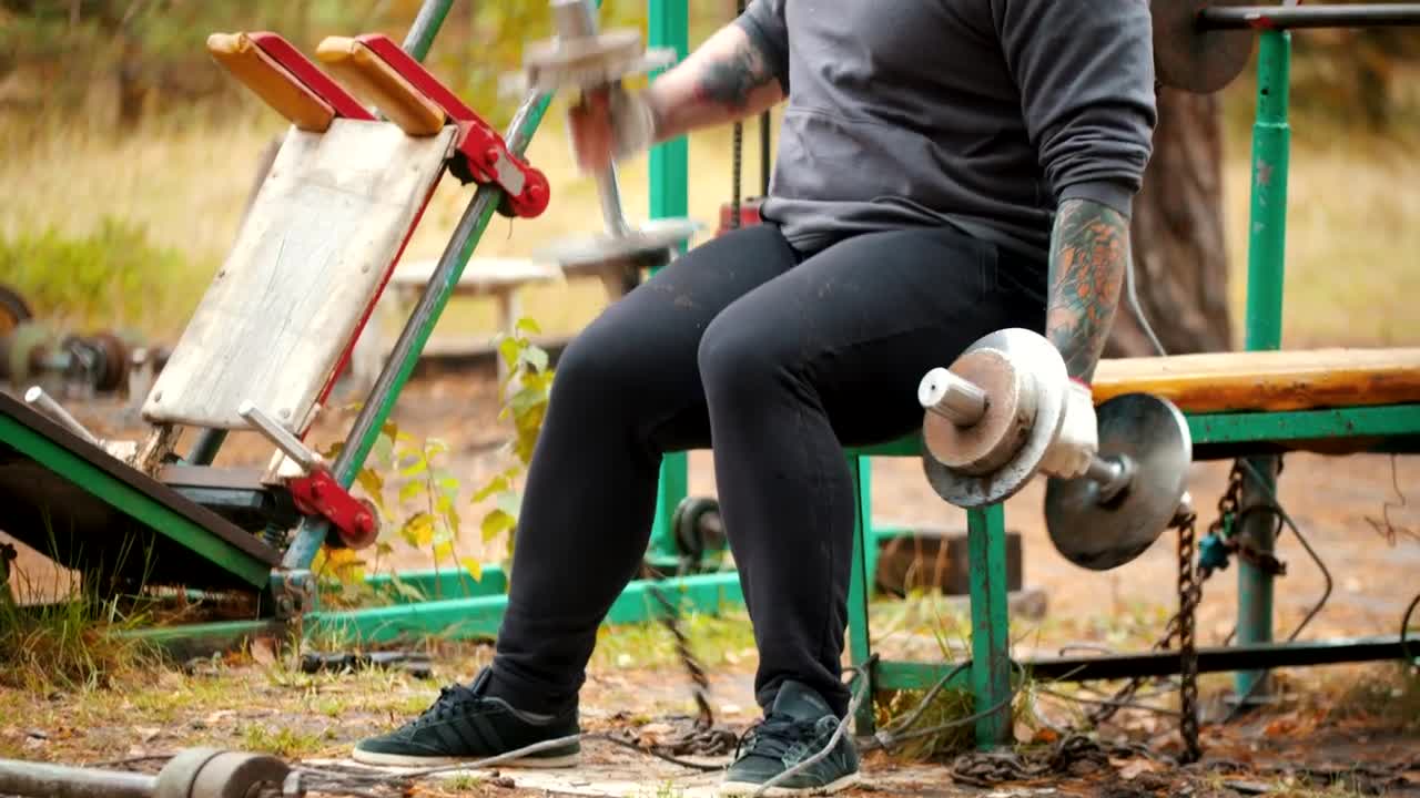 Stock Video Man In A Outdoors Gym With Dumbbells Animated Wallpaper