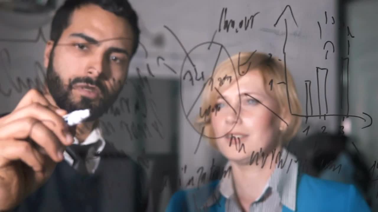 Stock Video Man Illustrates Idea On Glass Wall To Coworker Animated Wallpaper