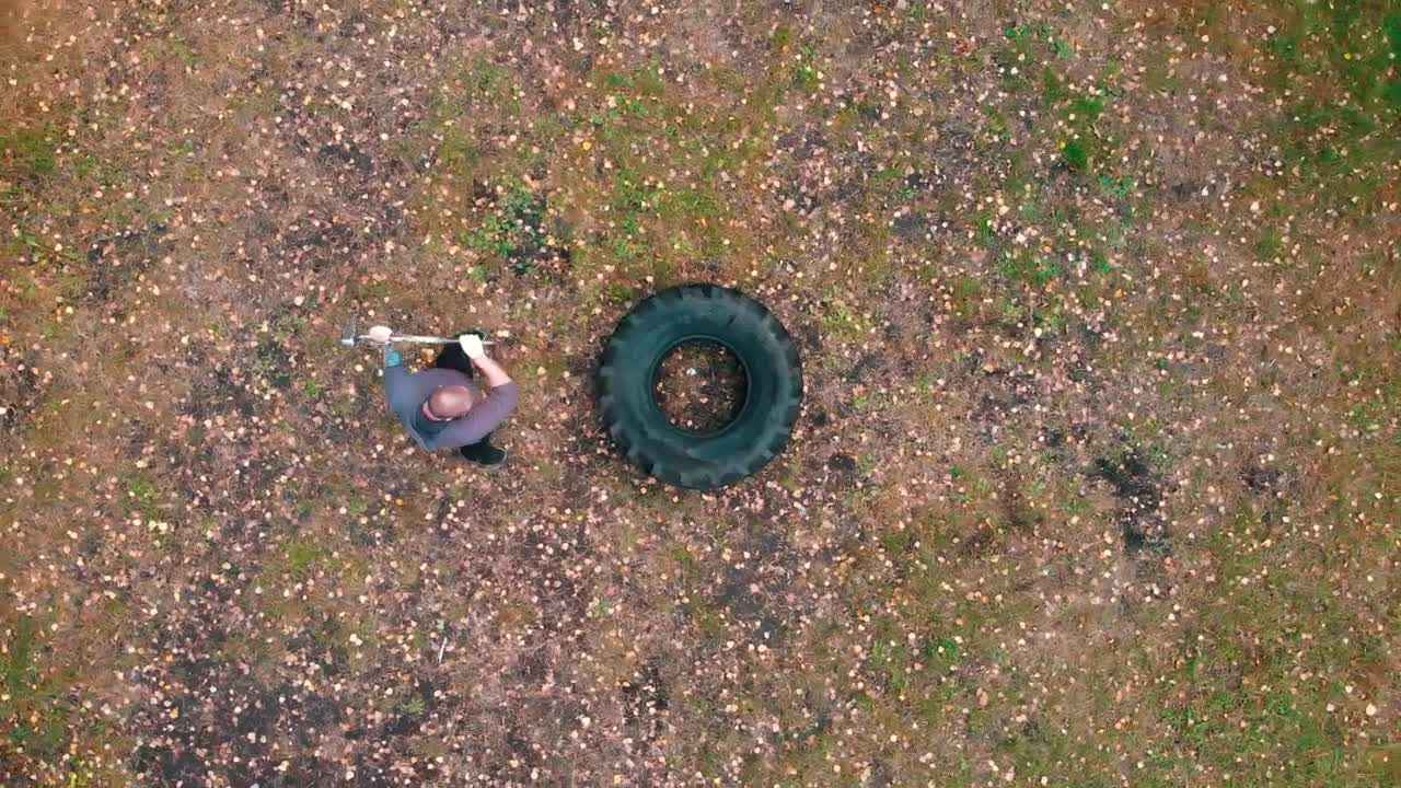 Stock Video Man Hitting A Large Truck Tire With A Mallet Animated Wallpaper