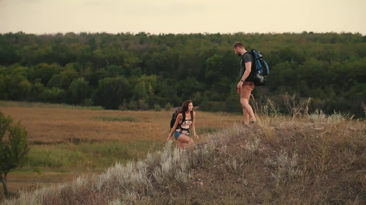 Stock Video Man Helps His Friend To Climb A Mound In Nature Animated Wallpaper