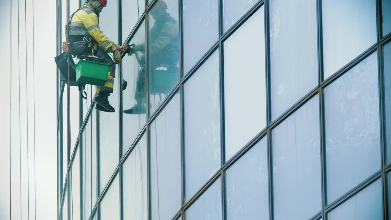 Stock Video Man Hanging On Ropes Cleaning Windows In A Building Animated Wallpaper