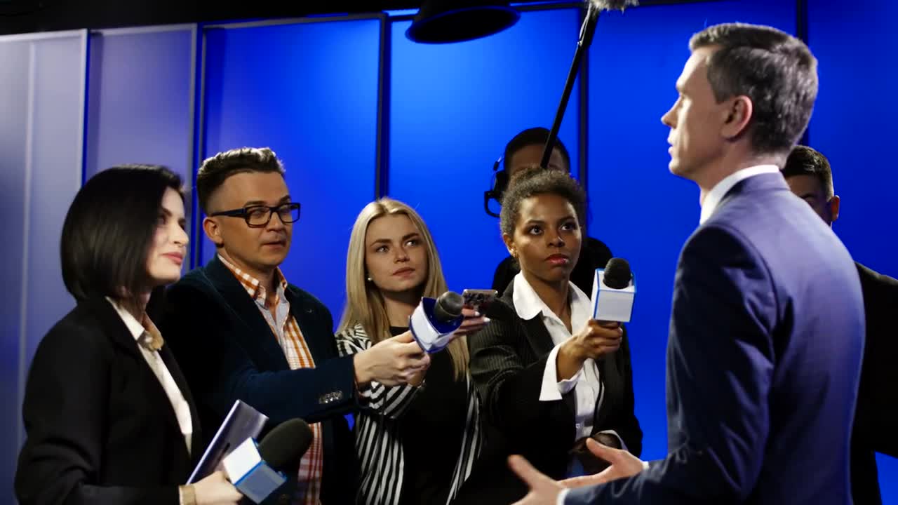 Stock Video Man Giving An Interview To A Group Of Reporters Animated Wallpaper