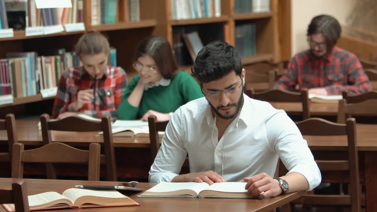Stock Video Man Focused On Study For Exam In Library Animated Wallpaper