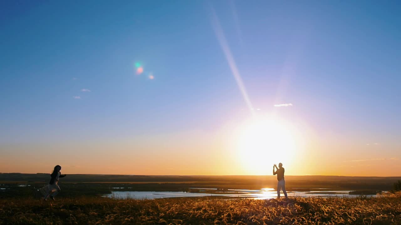 Stock Video Man Flying A Kite And A Girl Running At Sunset Animated Wallpaper