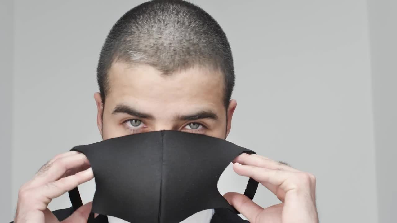 Stock Video Man Facing The Camera While Putting On A Mask Animated Wallpaper