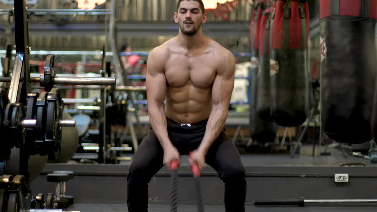 Stock Video Man Exercising With A Pair Of Ropes In The Gym Animated Wallpaper