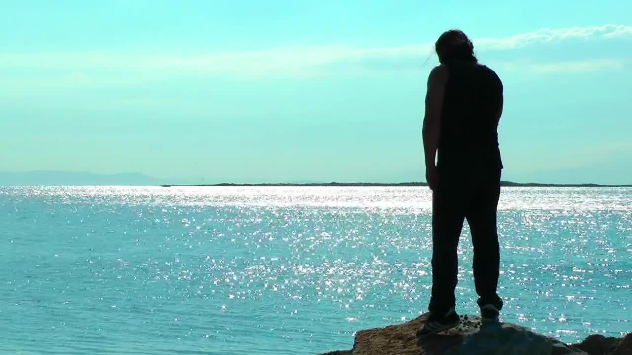 Stock Video Man Exercising On A Cliff By The Sea Animated Wallpaper