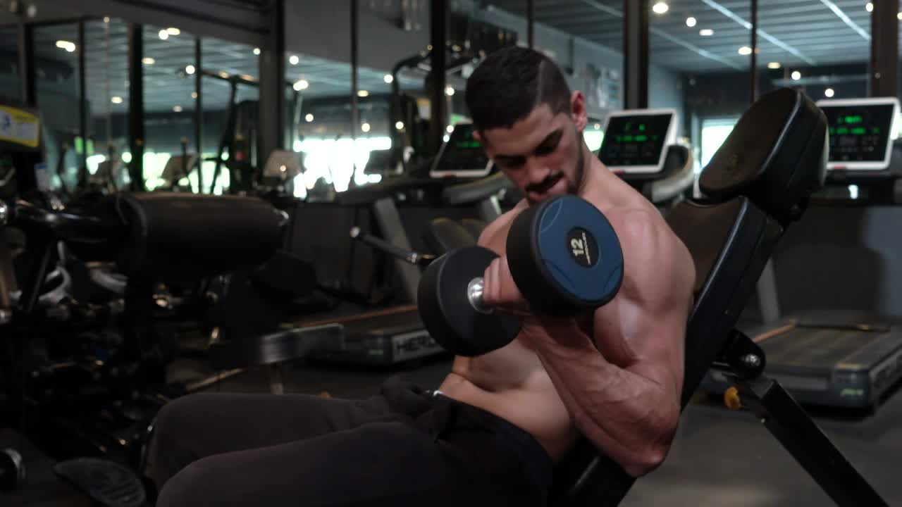 Stock Video Man Exercising Biceps In A Gym Animated Wallpaper