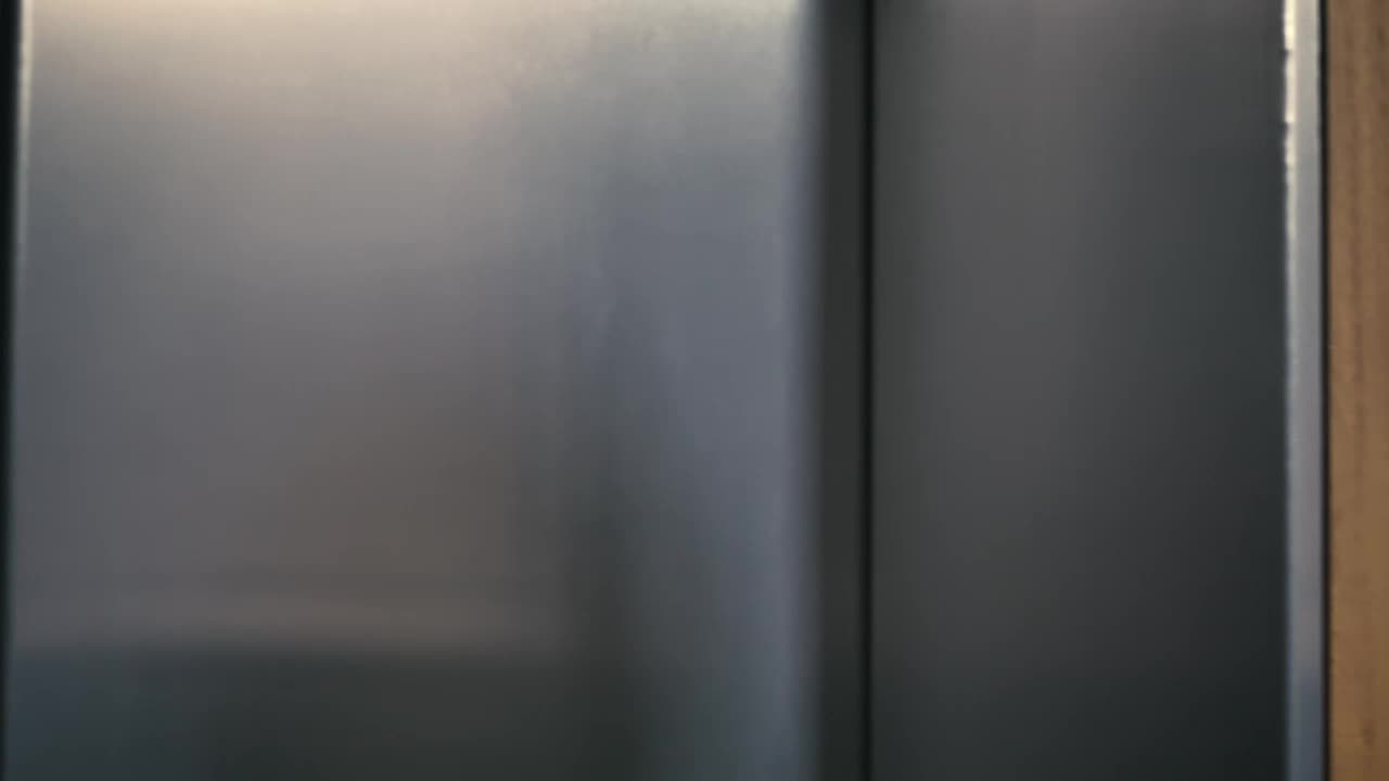 Stock Video Man Enters An Elevator Tapping His Wireless Earphones Animated Wallpaper