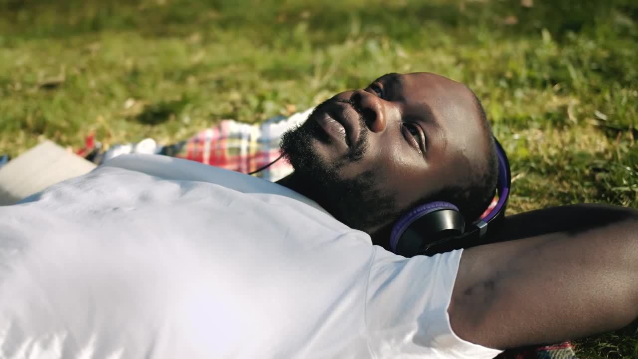 Stock Video Man Enjoying Music In The Park Animated Wallpaper