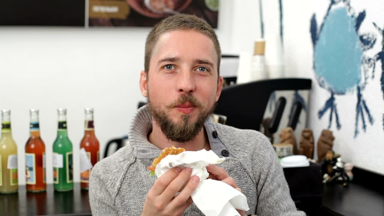 Stock Video Man Eating A Burger And Smiling Animated Wallpaper