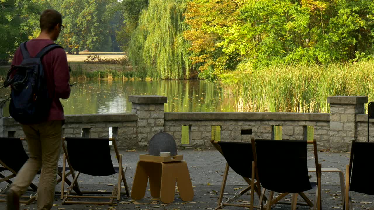 Stock Video Man Drinking Tea On The Shore Of A Lake Animated Wallpaper