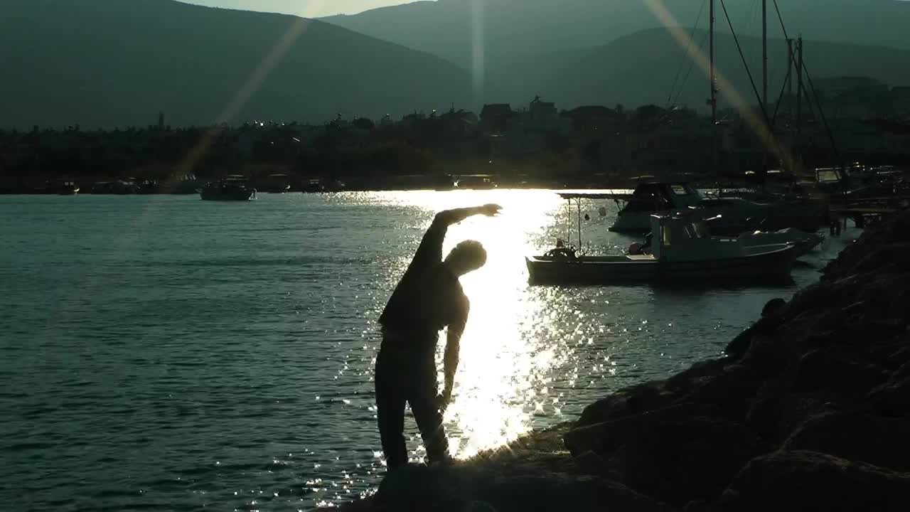 Stock Video Man Doing Stretching In Port At Sunrise Animated Wallpaper