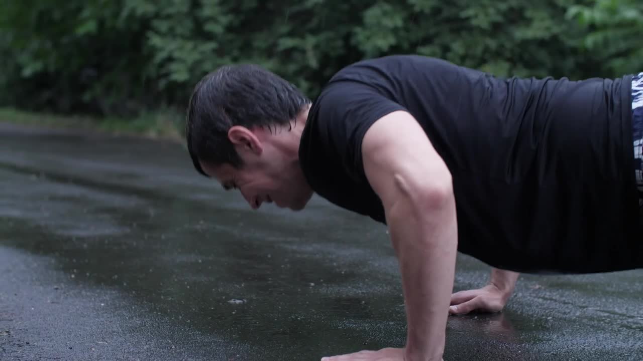 Stock Video Man Doing Hard Push Ups In The Rain Animated Wallpaper