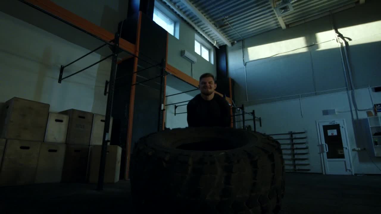 Stock Video Man Doing Crossfit Exercises With A Big Tire Animated Wallpaper