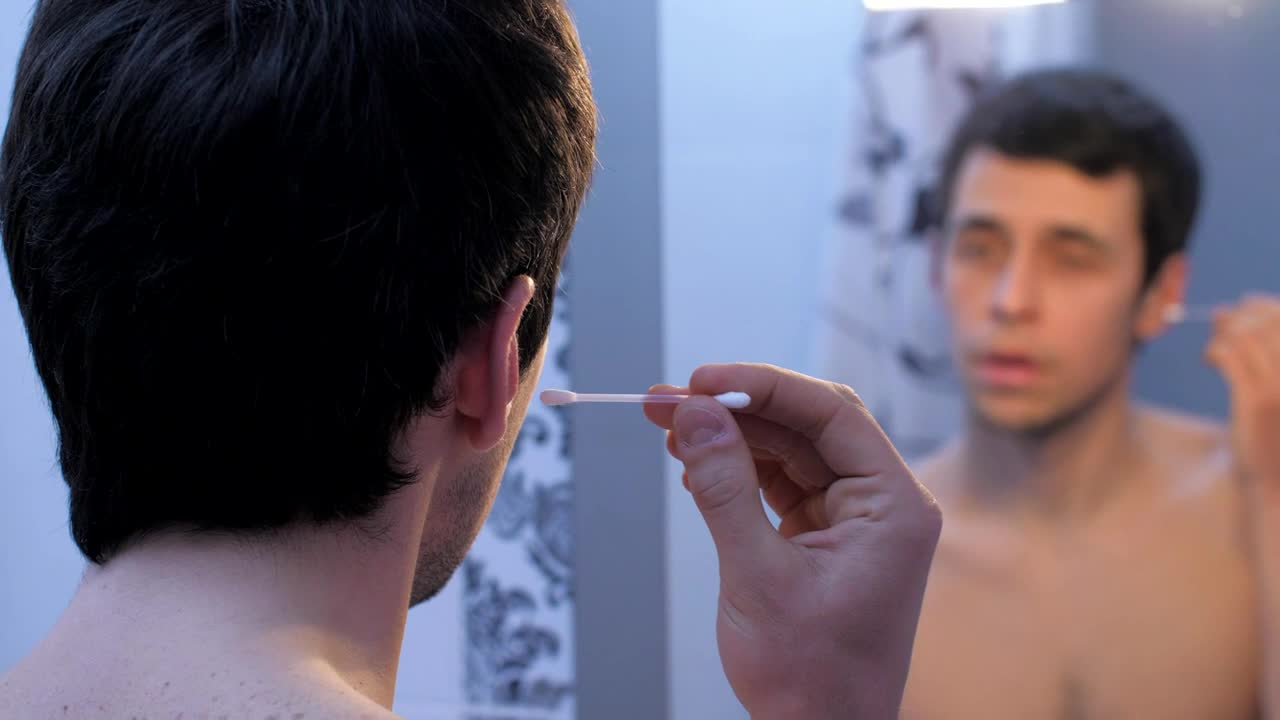 Stock Video Man Cleaning His Ears In The Bathroom Mirror Animated Wallpaper