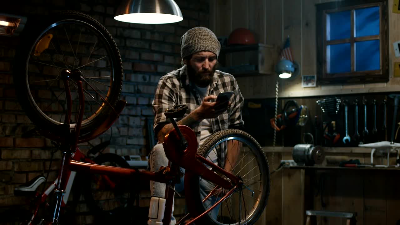 Stock Video Man Checking His Phone In The Garage Animated Wallpaper