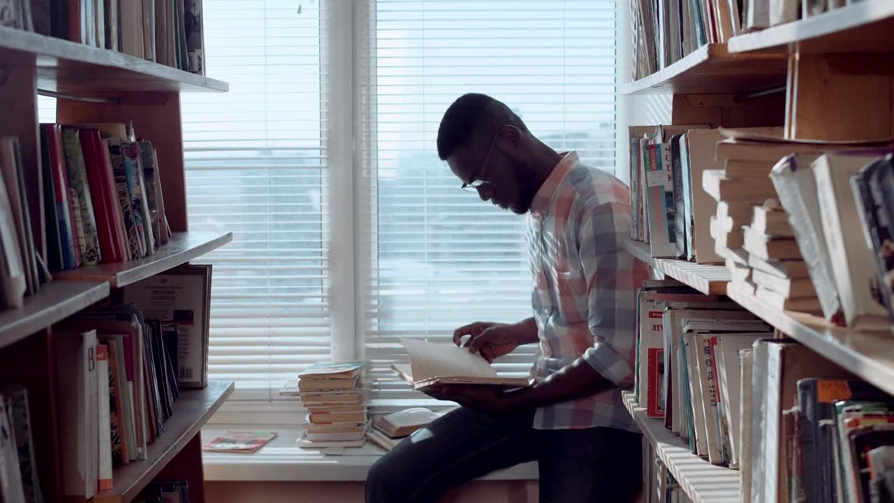 Stock Video Man Checking Books In The Library Animated Wallpaper