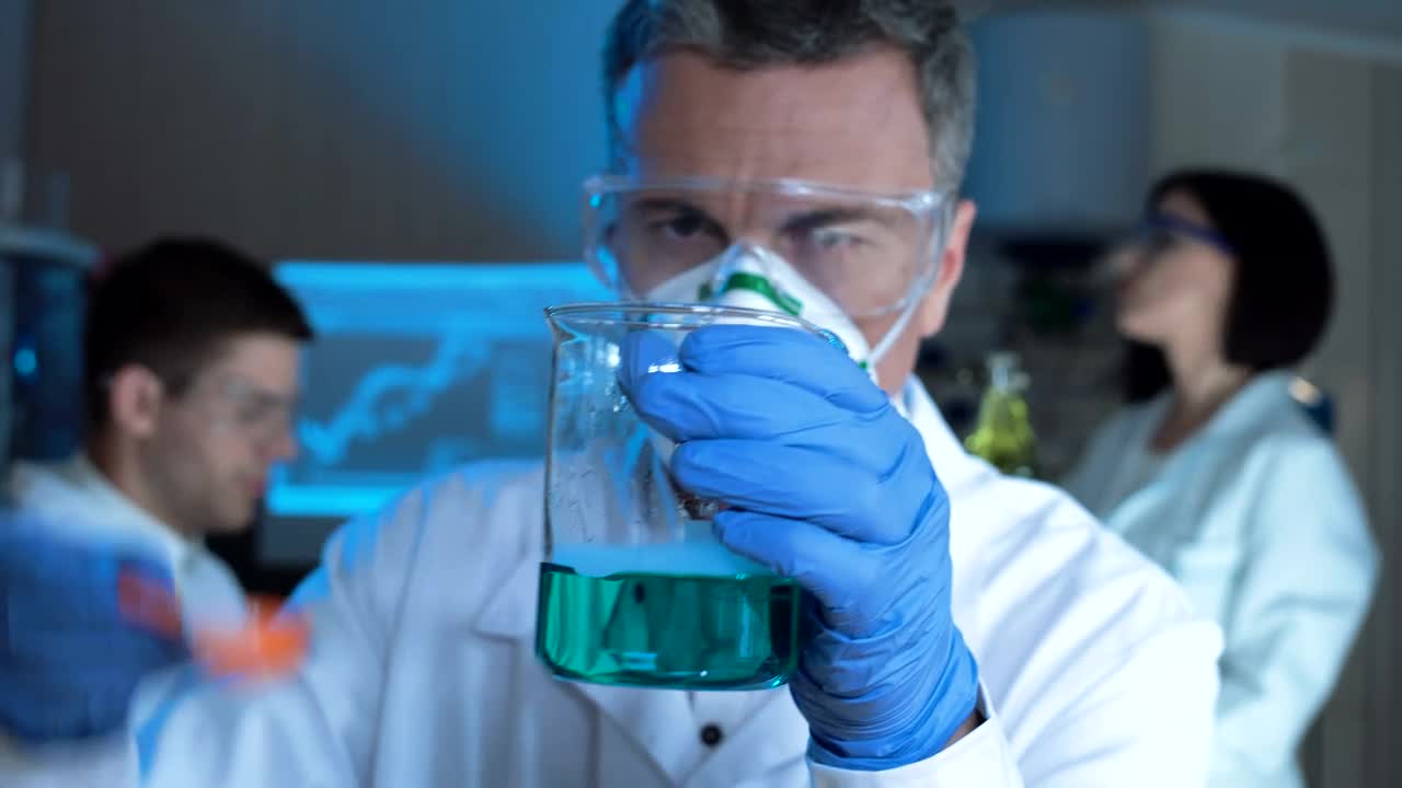 Stock Video Man Checking A Chemical Flask With Blue Liquid Animated Wallpaper