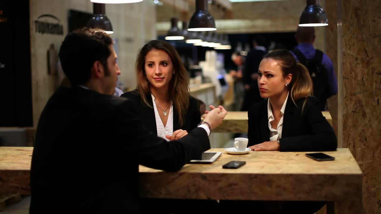 Stock Video Man Chatting With Two Women In A Cafe Animated Wallpaper