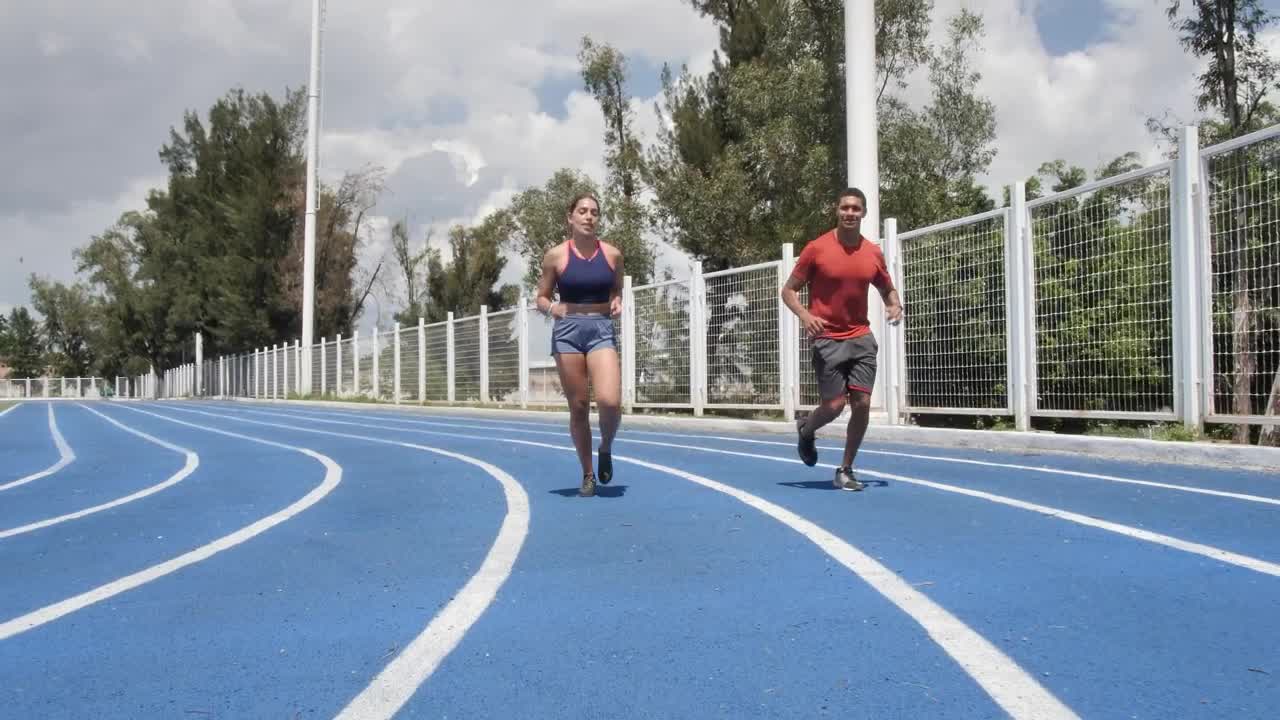 Stock Video Man And Woman Jogging On A Running Track Animated Wallpaper