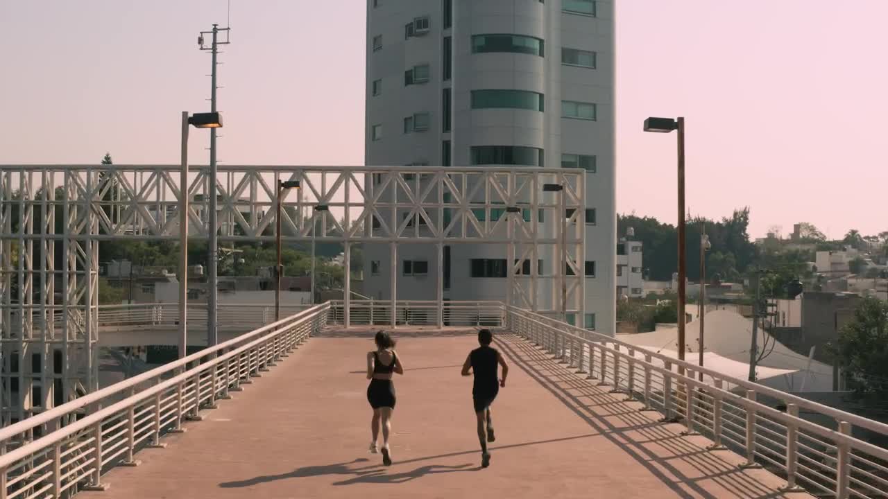 Stock Video Man And Woman Exercising On A Pedestrian Bridge Animated Wallpaper