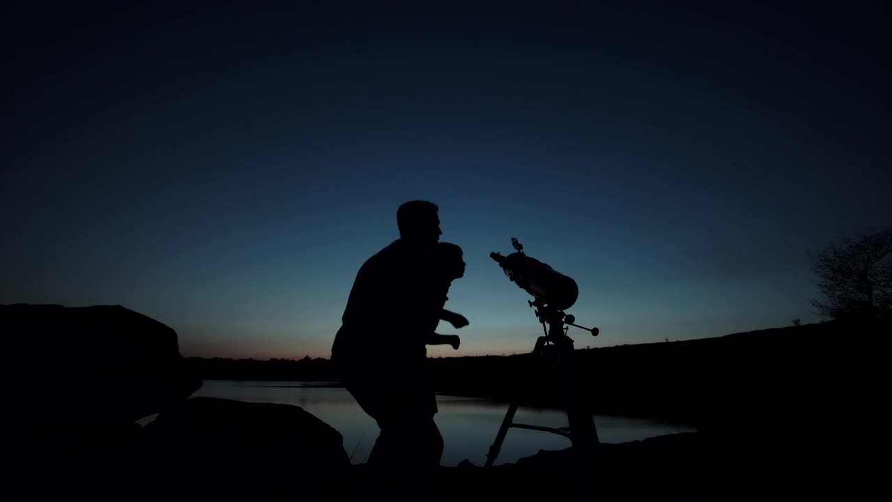Stock Video Man And A Boy You Using The Telescope At Dusk Animated Wallpaper