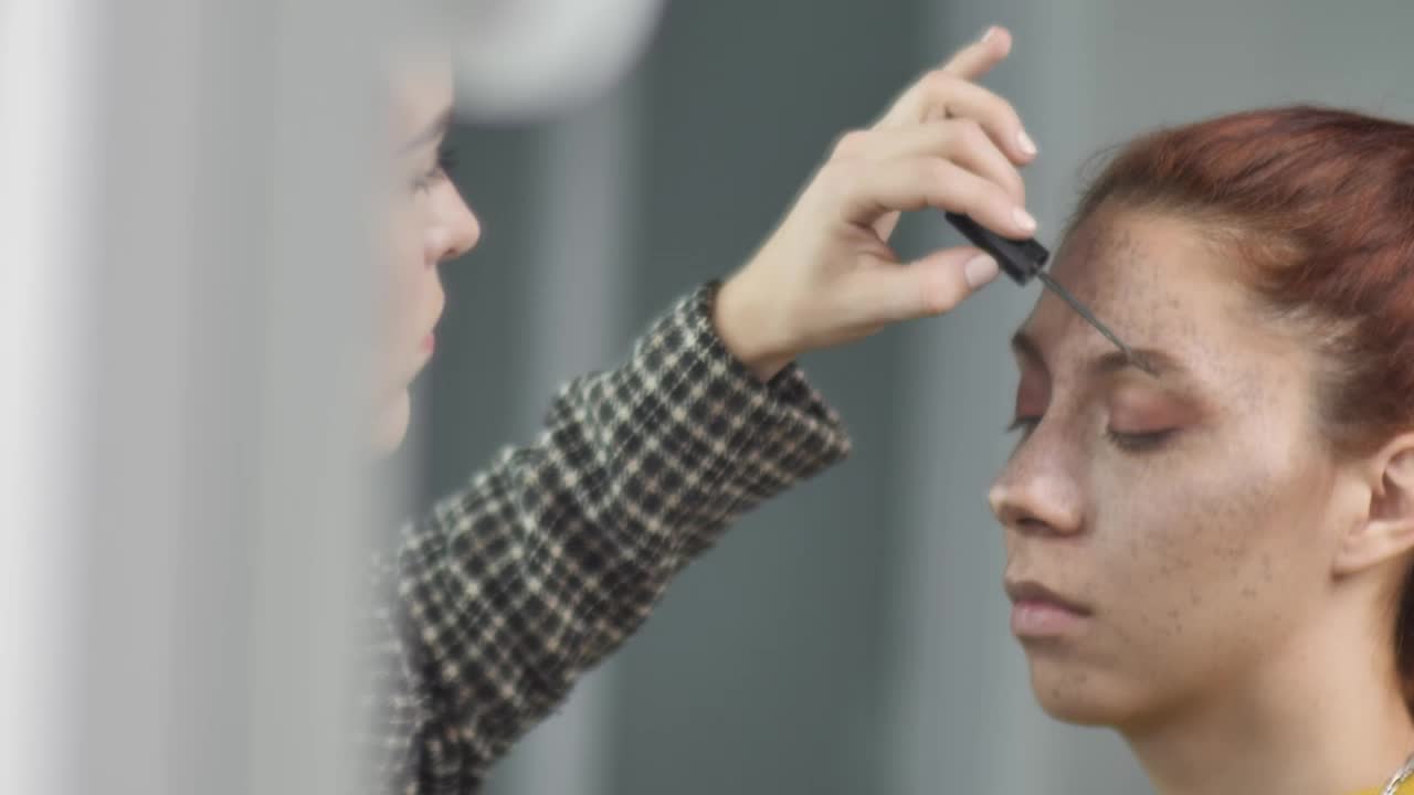 Stock Video Makeup Artist Putting Makeup On The Eyebrows Of A Young Animated Wallpaper