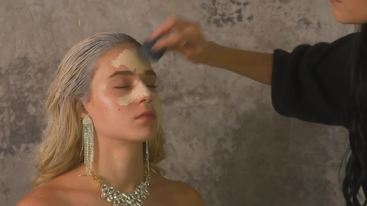 Stock Video Makeup Artist Applying Base To A Models Face Animated Wallpaper