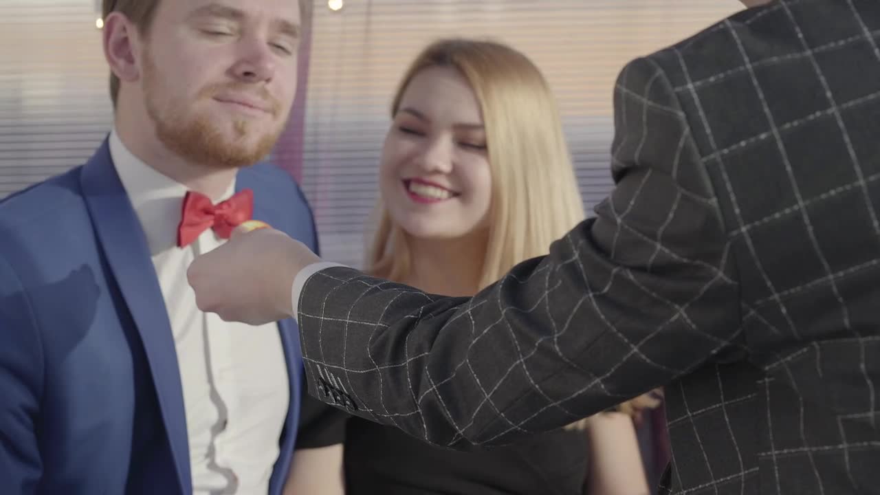 Stock Video Magician Wows Young Couple With Coin Illusion Animated Wallpaper