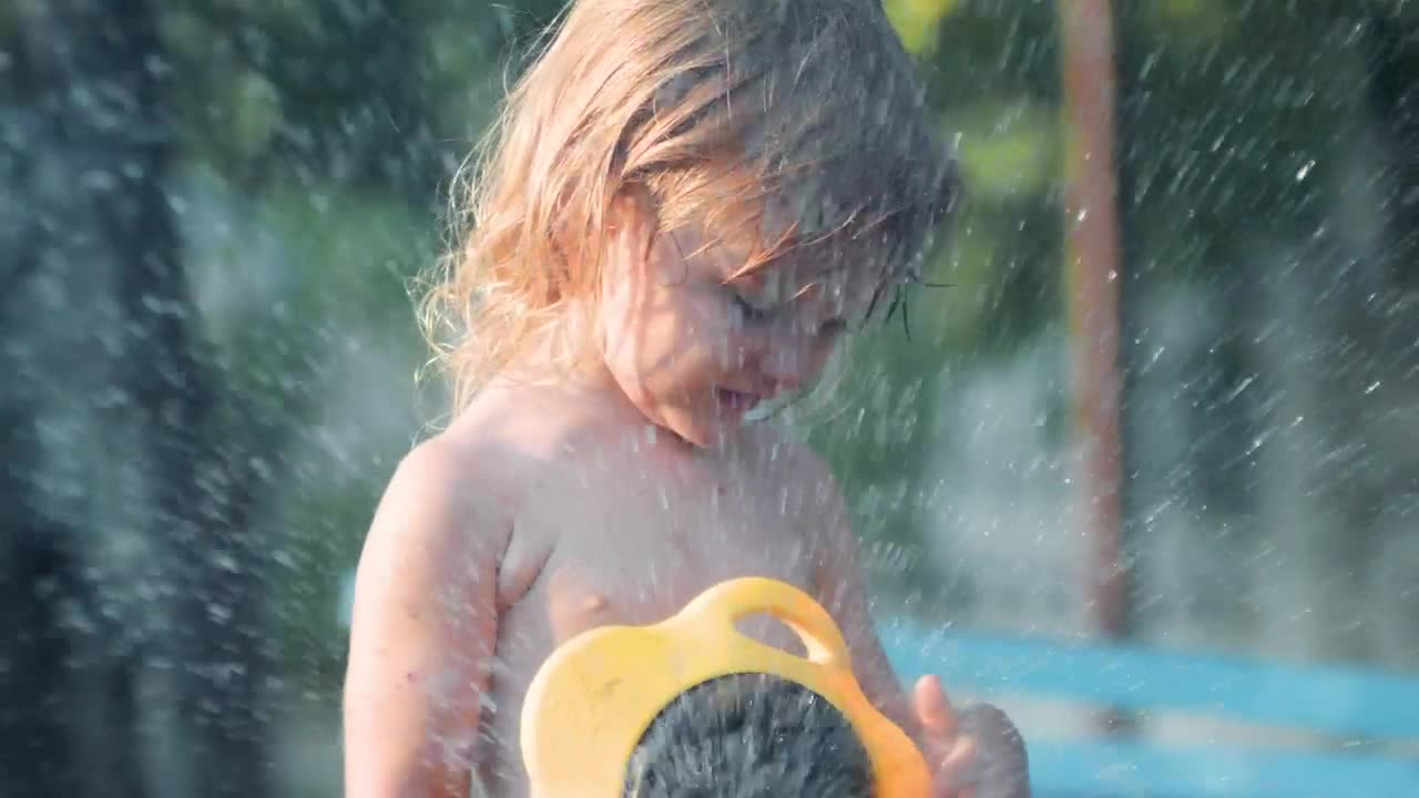 Stock Video Little Girl Playing With Water In The Garden Animated Wallpaper