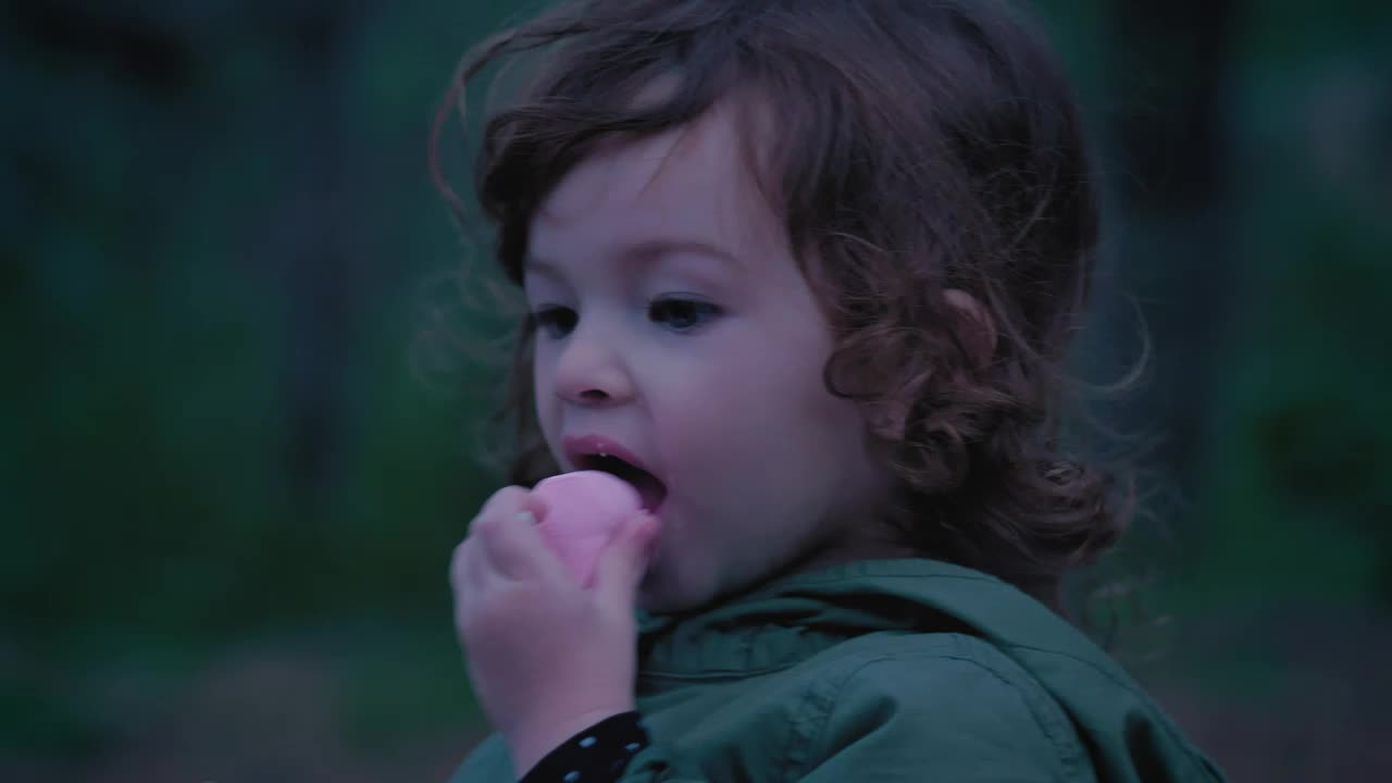 Stock Video Little Girl In Nature Eating A Marshmallow Animated Wallpaper