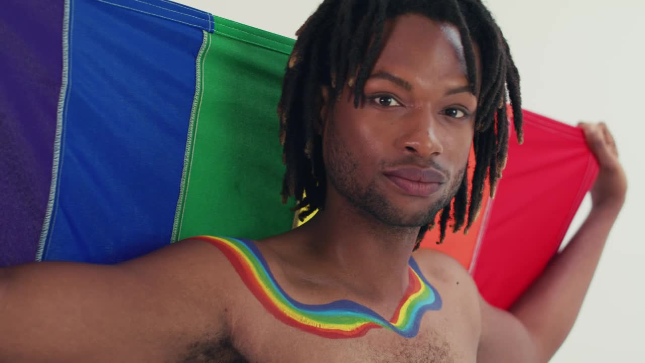 Stock Video Lgbtq Man Looking At The Camera With His Flag Animated Wallpaper