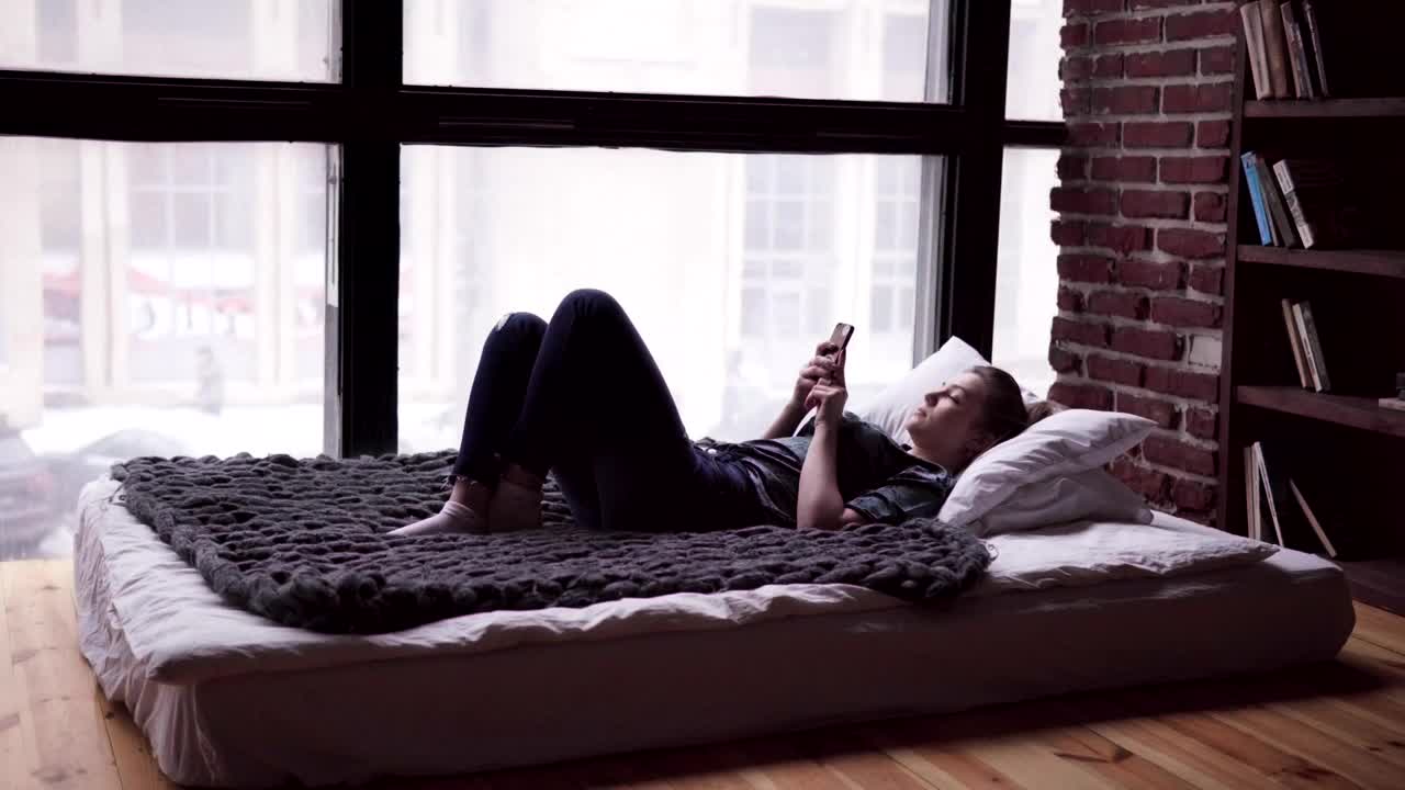 Stock Video Laying In Bed With Her Phone Animated Wallpaper