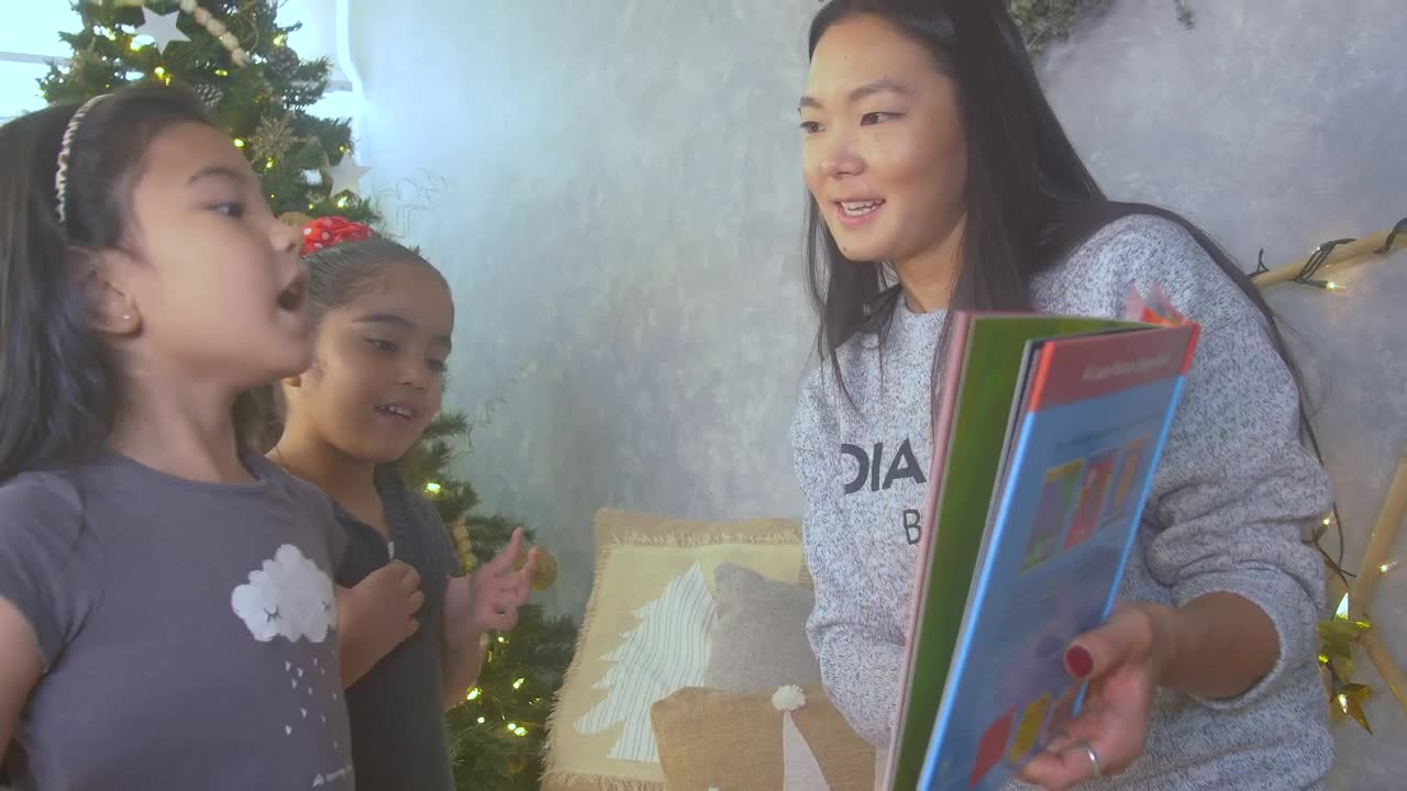 Stock Video Mother Reading A Book With Her Two Daughters At Christma Animated Wallpaper