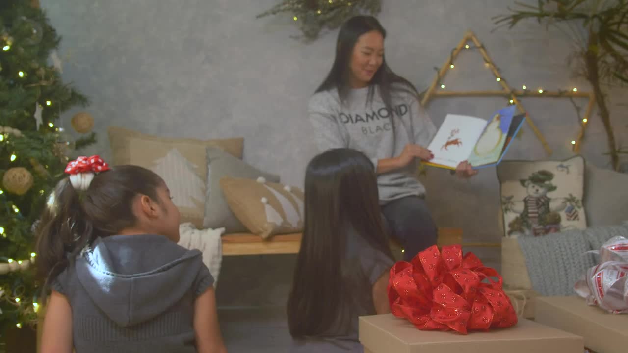 Stock Video Mother Reading A Book To Her Daughters At Christma Animated Wallpaper