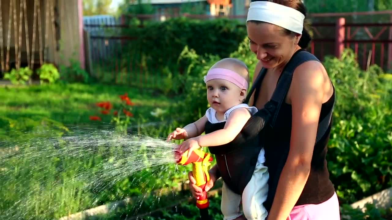 Stock Video Mom Watering The Garden With Her Bab Animated Wallpaper