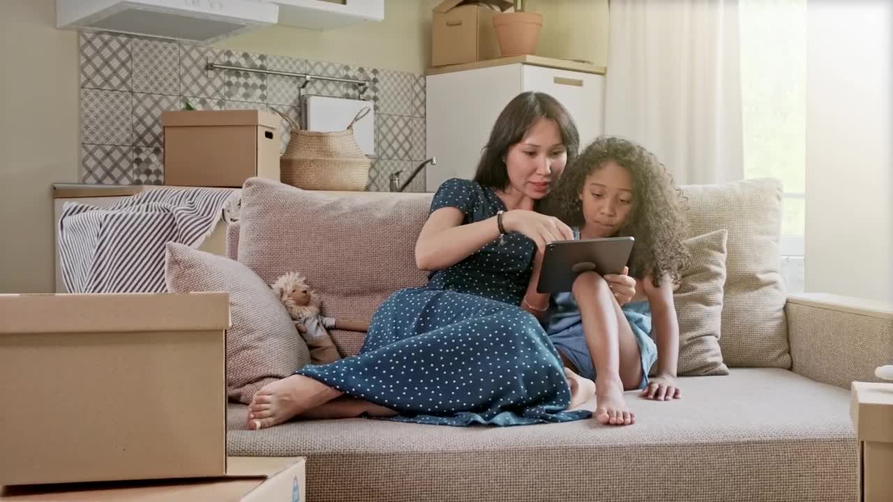 Stock Video Mom Teaching Something To Her Daughter On A Table Animated Wallpaper