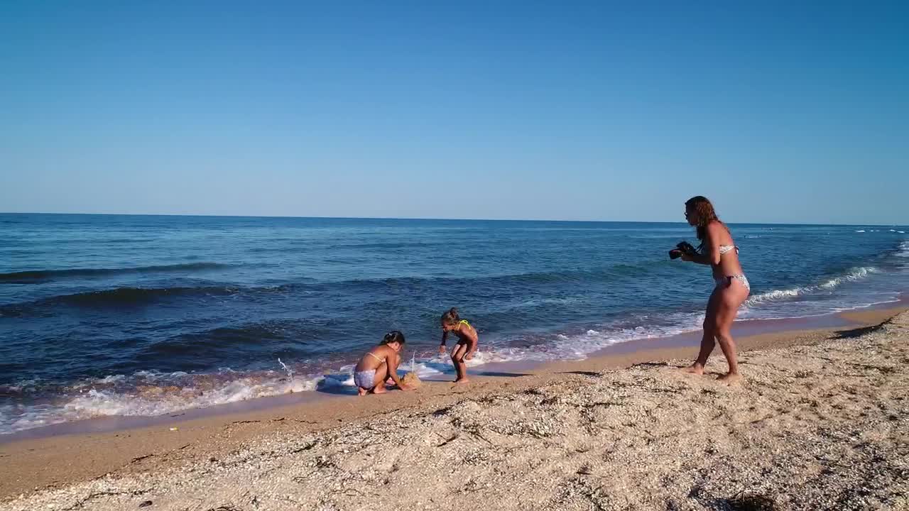 Stock Video Mom Taking Photos Of Her Daughters Sand Pyramid Animated Wallpaper