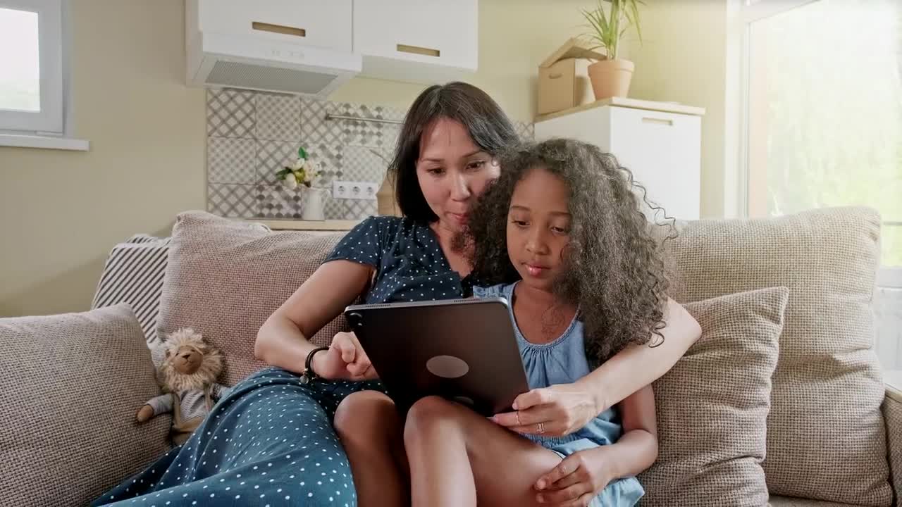 Stock Video Mom And Daughter Use Tablet On Sofa In New Apartmen Animated Wallpaper