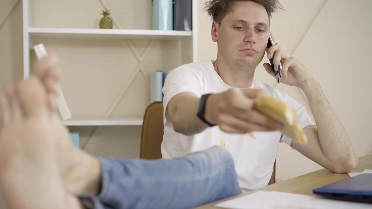 Stock Video Messy Guy Eating Pizza And Talking On Mobile Phon Animated Wallpaper