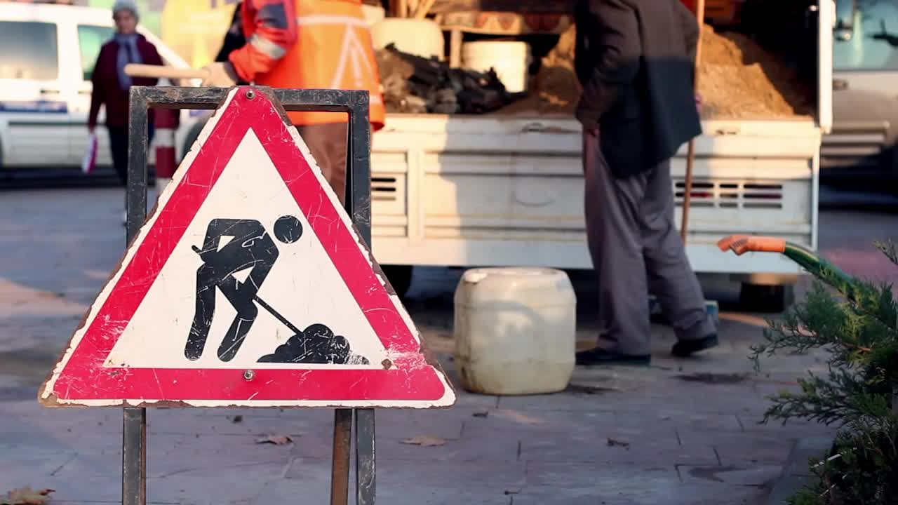 Stock Video Men Cleaning A Street With A Dirt Road Sign Animated Wallpaper