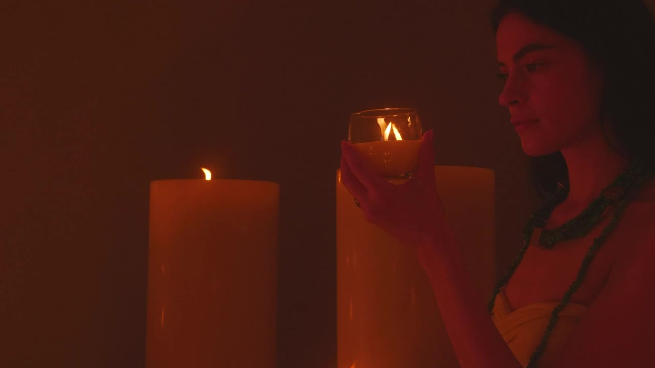 Stock Video Meditative Woman Appreciating A Small Candl Animated Wallpaper